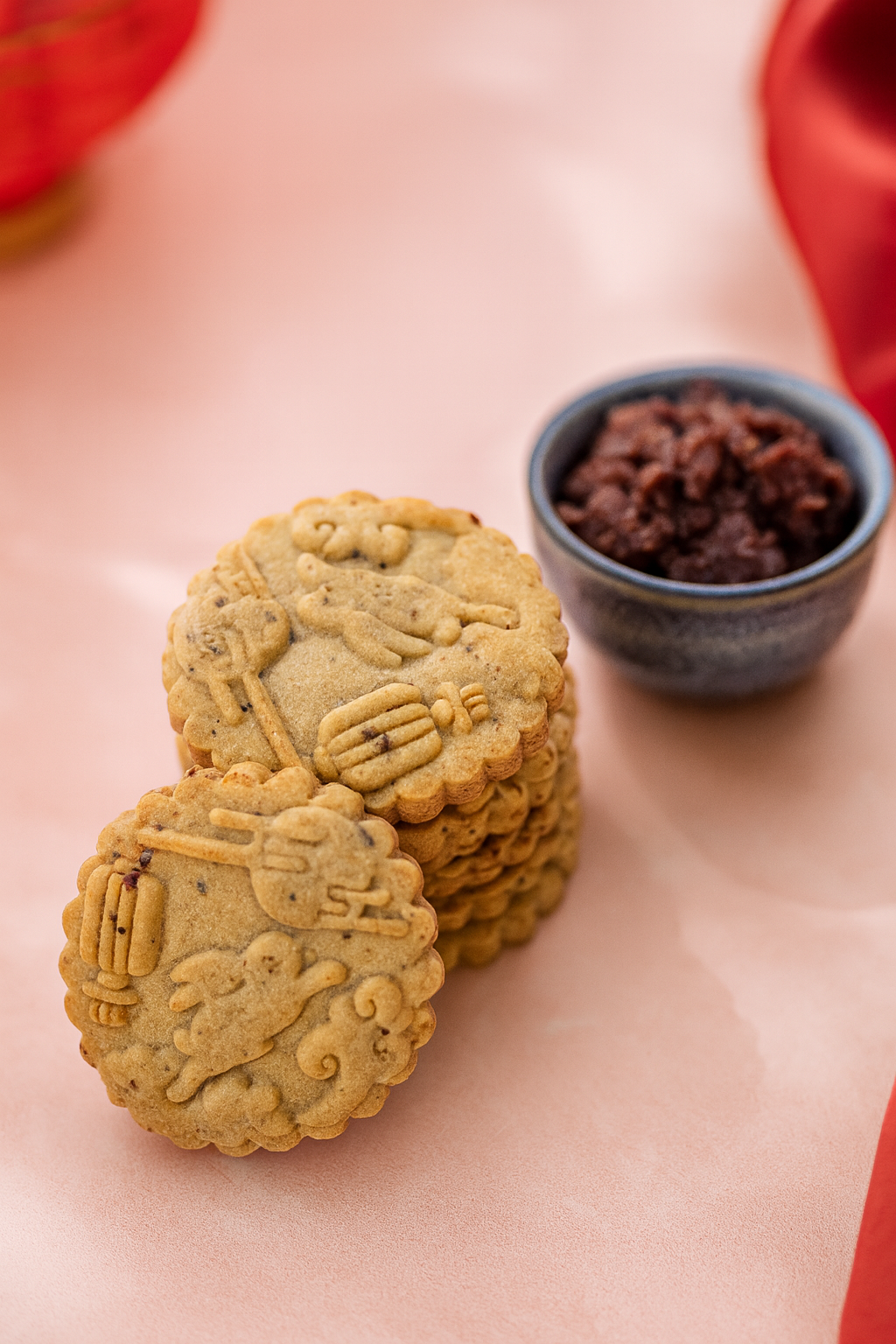 Close-up moon-pattern cookie with red bean filling props – elegant pastel styling